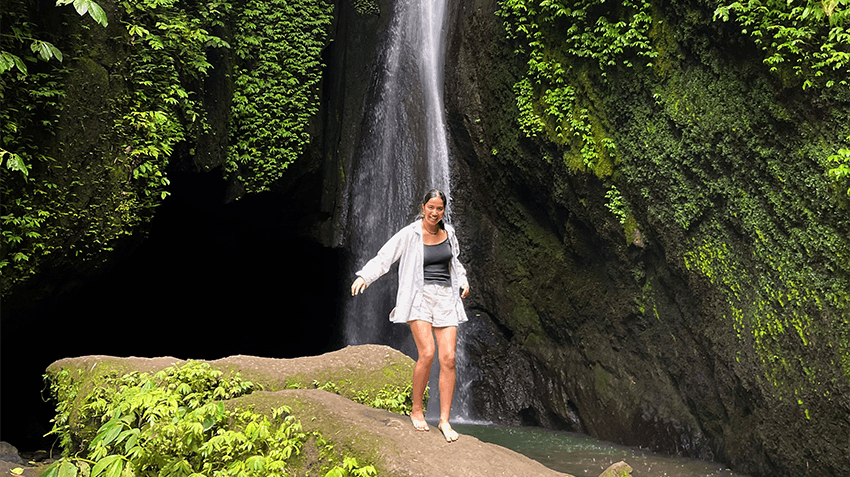 Intern exploring a lush rainforest waterfall in Bali, Indonesia during a free day from their summer internship experience.